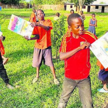 Ganz viel Freude bereiten - Die Kids präsentieren stolz den Flyer für den afrikanischen Familientag.