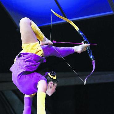 Das Leben etwas bunter gestalten - Auf diese Art einen Pfeil zu schiessen, ist schwierig genug. Anne Arellano trifft aber auch haargenau ins Ziel. Perfekt kombiniert sie Handstandartistik und Kontorsion.