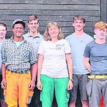 Berghilfe aus dem Aargau - Ein Gruppenbild zum Abschluss: alle Lernenden, die drei Lehrlingsbetreuer sowie das Bauern-Ehepaar vor der umgebauten Scheune. Bild: zg