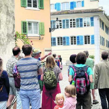 Das Schlössli öffnet sich für Stadtführungen - Stadtführer Rolf Roth (Mitte, links, mit Hut) erklärt den Gästen die astronomische Uhr am Spittelturm aus dem 16. Jahrhundert. Bild: Reto Jäger