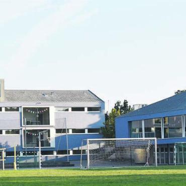 Alle brauchen mehr Platz - Im Schulhaus (hinten) und in der Sporthalle (rechts) ist es eng, zu eng, geworden. Bild: Erika Obrist