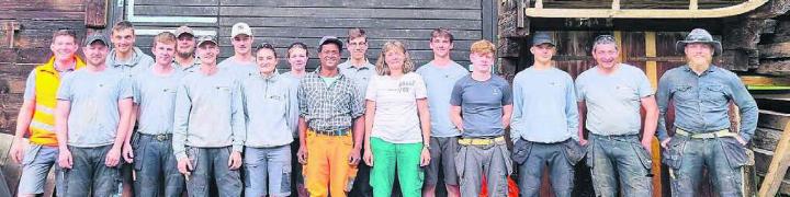 Ein Gruppenbild zum Abschluss: alle Lernenden, die drei Lehrlingsbetreuer sowie das Bauern-Ehepaar vor der umgebauten Scheune. Bild: zg