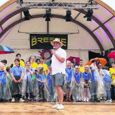 Lebendiger Regenbogen - Mit einem breiten Strahlen trotzen die Kinder zusammen mit OK-Präsident Matthias Oldani dem Regen an der Eröffnungsfeier.