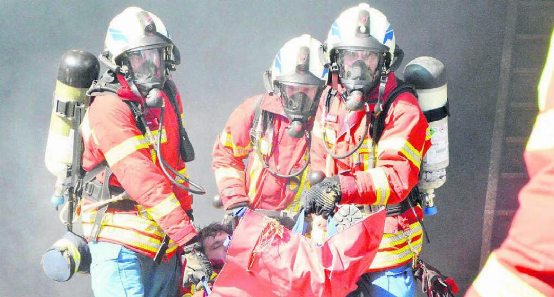 Der Atemschutz-Trupp rettet einen Verletzten aus der brennenden Scheune. Bilder: Celeste Blanc