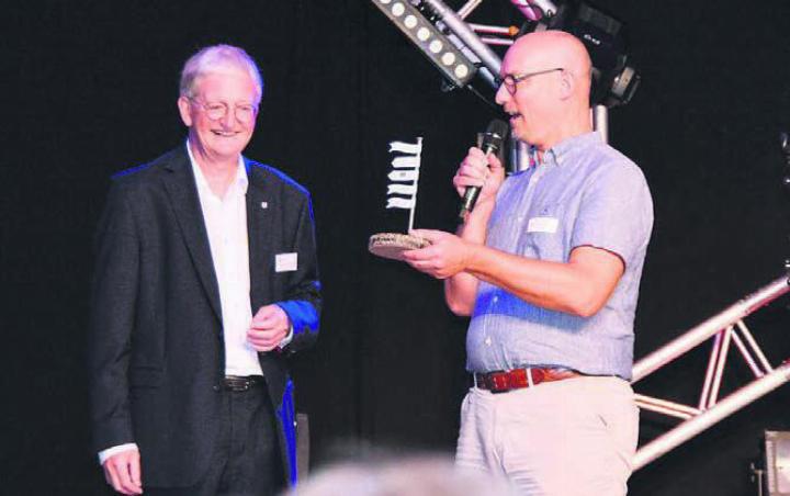 Martin Bühler (Abteilung Tiefbau, rechts) schenkt Gemeindeammann Peter Hochuli ein kleines Schiffchen aus Flüsterbelag zur Erinnerung. Bild: ake